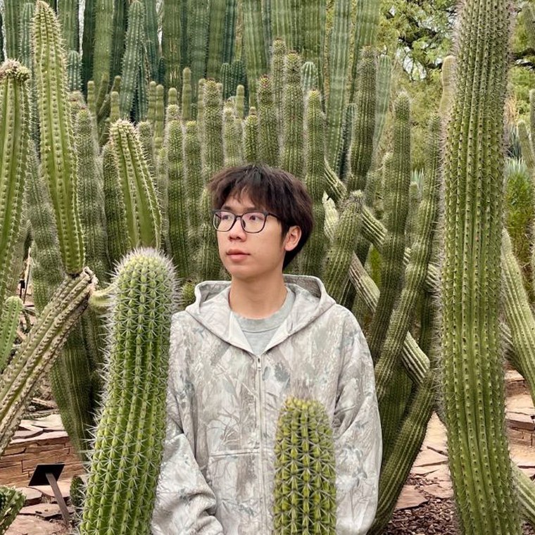 Yuwei Xiao standing among tall cacti