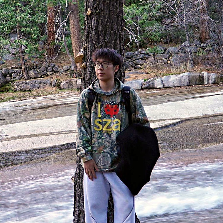 Yuwei Xiao by a river over granite in a pine forest
